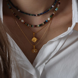 Layered gold titanium necklaces with evil eye, coin pendants and colorful bead strands