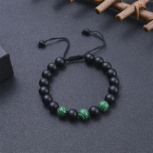 Detail of adjustable tiger eye stone bracelet with matte black beads and green accents
