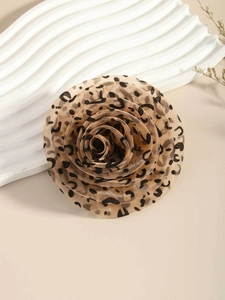 Detailed view of layered leopard print chiffon flower brooch on elegant beige backdrop