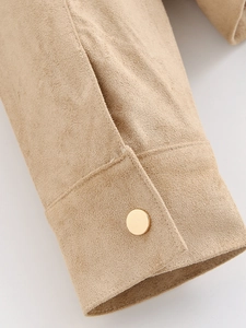 Detail shot of khaki suede jacket cuff with stitching and gold metal button decoration
