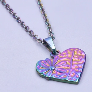 Vue macro d'un pendentif cœur iridescent avec détail de fleur sur une chaîne en O maille