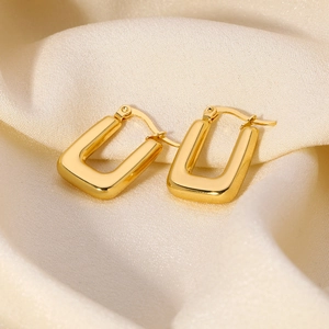 Minimalist 18K gold stainless steel square hoop earrings on soft beige fabric background