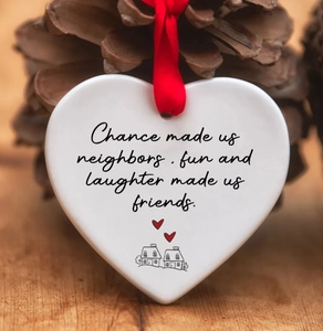 Ceramic heart ornament with red ribbon and friendship poem on a festive wood background