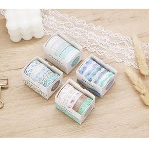 Detail of four watercolor washi tape boxes with geometric and forest patterns