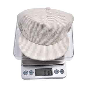 Detail of light beige corduroy flat brim cap showing cactus embroidery and 84.8g weight