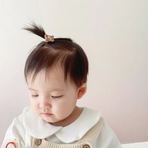 Cute brown 3D bear hair tie for babies made of smooth resin material on a little girl