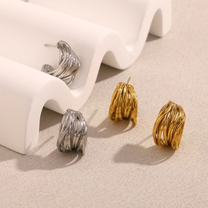 Dettaglio orecchini a spirale a forma di C geometrica in oro e argento lucido
