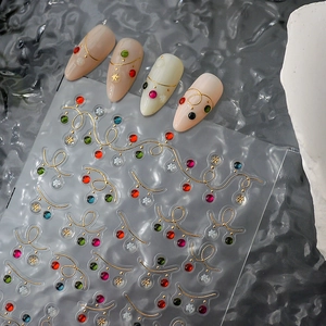 Christmas nail stickers with gold wavy lines, colorful rhinestones and white snowflakes