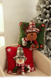 Detail of Christmas pillow cases with 3D snowman and elk motifs in festive plaid hats