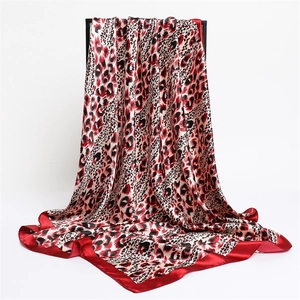 Elegant leopard print satin silk scarf with bold red borders and a glossy finish