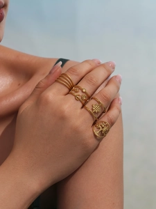Close-up of bohemian style 18k gold plated stainless steel rings set worn on hand