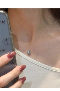 Dettaglio di una collana in argento con ciondolo tondo in zircone indossata da modella