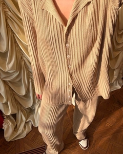 Detail of khaki ribbed knit polo set showing button cardigan texture and drape