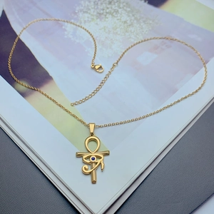 Detailed close-up of golden Ankh and Eye of Horus pendant with blue zircon stone inlay