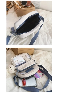 Détail de la capacité intérieure du sac bandoulière en toile et design multi-poches bleu
