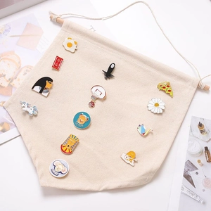 Detail of beige canvas banner displaying colorful enamel pins and collectible badges