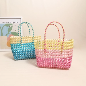 Colorful hollow woven straw beach bags in blue and pink gradients for summer vacations