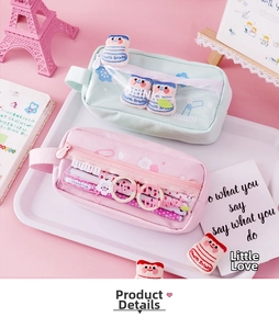 Detail of pink and green canvas pencil cases with transparent windows and plush charms
