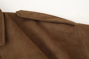 Detail of shoulder epaulettes and stitching on brown suede bomber jacket