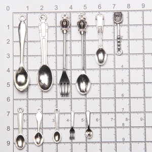 Macro view of miniature alloy spoon and fork set for dollhouse accessories with size scale