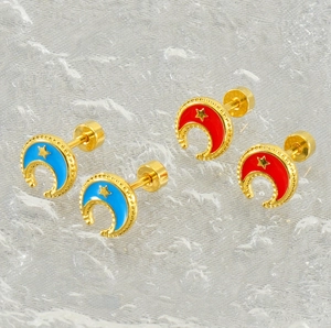 Close-up of 18k gold-plated star and moon earrings with red and blue enamel details