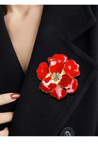 Close-up of elegant red enamel rose brooch with crystals on a black wool coat