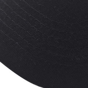 Dettaglio macro del tessuto twill nero con cuciture parallele sulla visiera del cappello