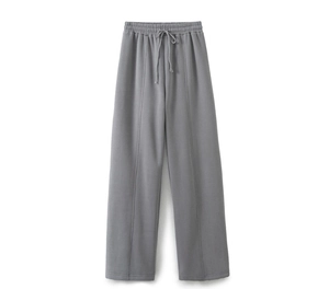 Detail of grey knitted wide-leg track pants with elastic drawstring waist and vertical seams