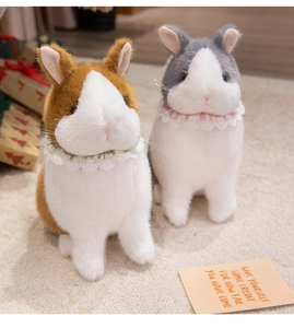 Detail of plush bunny dolls with lace collars on a soft carpet for gift decoration