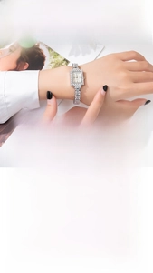 Close-up of women's silver square watch with sparkling rhinestones on the chain band