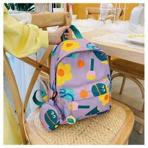 Close-up of purple kids backpack with floral print and matching coin purse on a chair