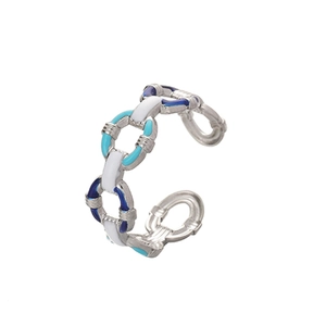 Detail of silver chain link open ring with blue and white enamel inlay patterns