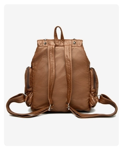 Close-up of vintage brown backpack showing detailed lychee grain texture and metal rivets