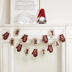Christmas bunting with red plaid and burlap gloves hanging on a cozy white fireplace