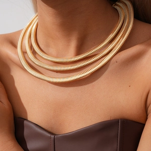 Detailed view of triple-layered golden snake chain necklace on model neck for styling