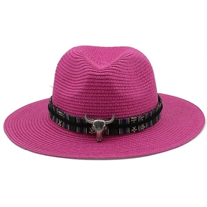 Detail of rose red straw hat with ethnic tribal band and silver bull head pendant decoration