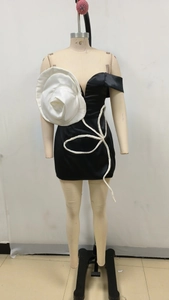 Détail de robe moulante avec rose 3D géante et contours de pétales en perles blanches