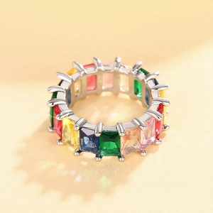 Detail van zilveren eternity ring met kleurrijke smaragdgeslepen edelstenen