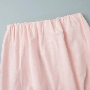 Vue détaillée du tissu rose en coton et lin avec une texture de taille élastique plissée