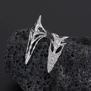 Detailed close-up of Gothic silver armor ring with clear zircon on dark volcanic rock