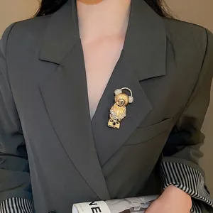 Golden bear brooch with sparkling rhinestones pinned on a dark grey suit lapel