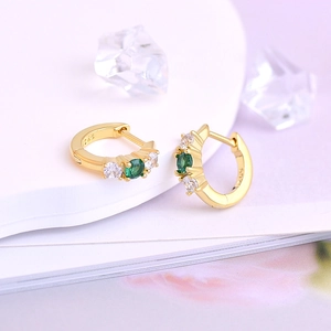 Close-up of S925 sterling silver hoop earrings with green and white zircon stones