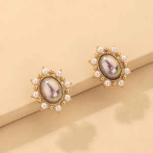 Detail of vintage French style gold earrings with oval faux pearl and white bead trim