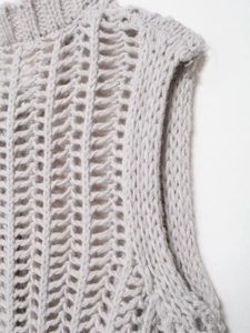 Dettaglio del gilet grigio in maglia a trecce con trama traforata e scollatura