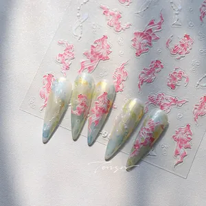 Macro view of 3D koi fish nail art stickers with pink gradient on stiletto nails