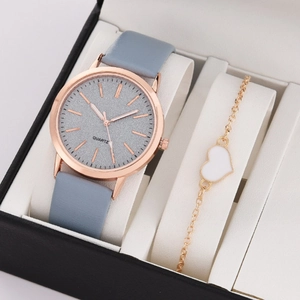 Close-up of elegant rose gold quartz watch and white heart bracelet in a gift box