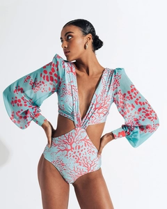 Detail view of light blue swimsuit with coral print and deep V-neck lantern sleeves