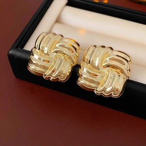 Close-up of gold square twist earrings placed inside a black jewelry gift box