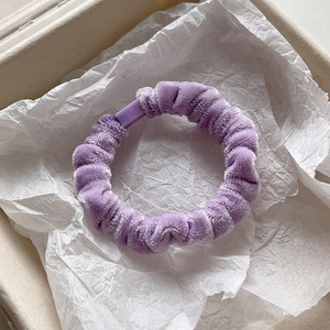 Close-up of a purple velvet scrunchie placed in a white gift box for elegant presentation