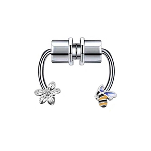 Macro detail of magnetic nose rings featuring flower and bee charms in silver finish